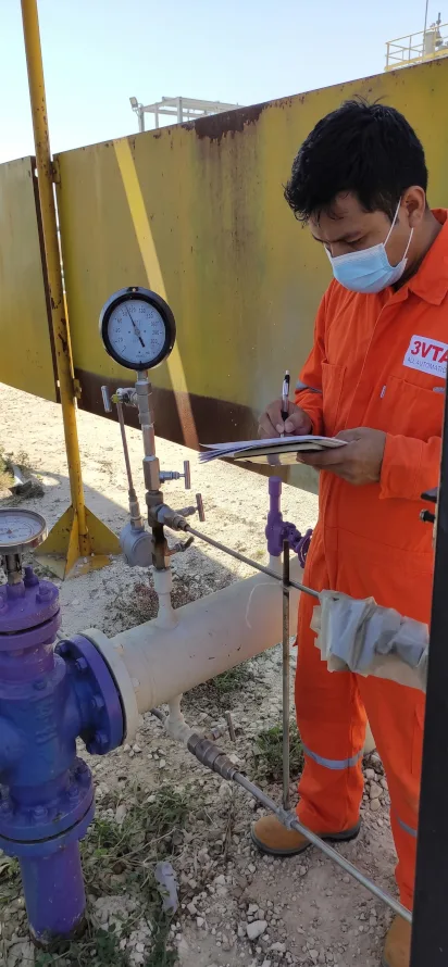 Operador industrial midiendo presión y realizando inspección de válvulas en planta de procesos, monitoreo y mantenimiento técnico